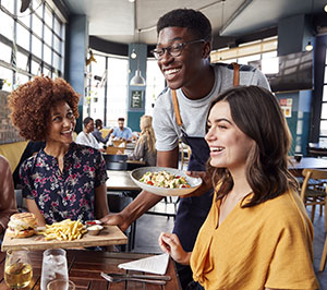 Waiter serving food to table in resturant