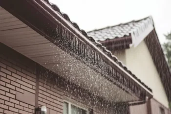 Rain flowing off of a roof during a hurricane.