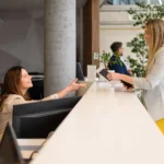 Hotel guest speaking with front desk employee in North Carolina hotel