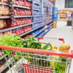 Shopping cart with a variety of food in the isles of a grocery store. Top Pest Threats in Food Retail and How to Prevent Them