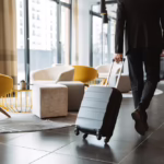 A traveler walks with his suitcase through the hotel lobby. Learn how to prevent bed bugs while traveling with these tips.