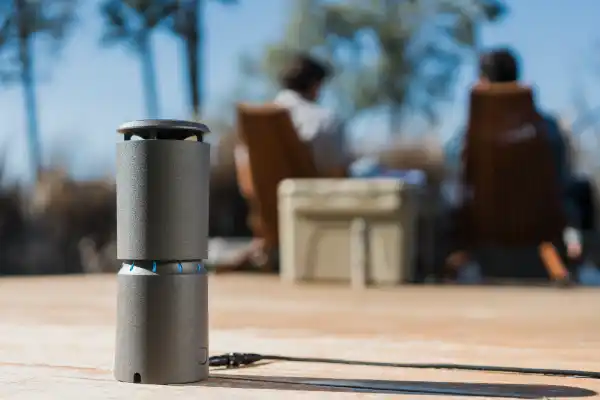 Dark grey cylindrical Thermacell device for Mosquito Repelling placed outside a residential patio.