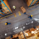 Aerial view of warehouse floor as facility workers transport products. Bug Out uses integrated pest management techniques for an eco-friendly approach to pest control.
